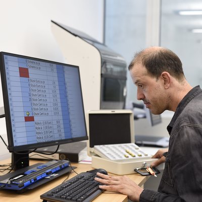 Ein Mann verwaltet eine Bestandsliste am Computer
