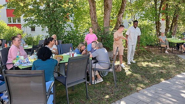 Eine Gruppe von Menschen bei einem sommerlichen Gartenfest.