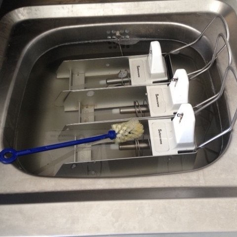 Das Foto zeigt Seifenspender im Waschbecken, die gewaschen werden sollen