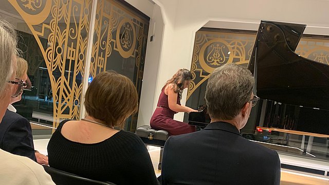 Publikum lauscht dem Spiel einer Pianistin am Flügel