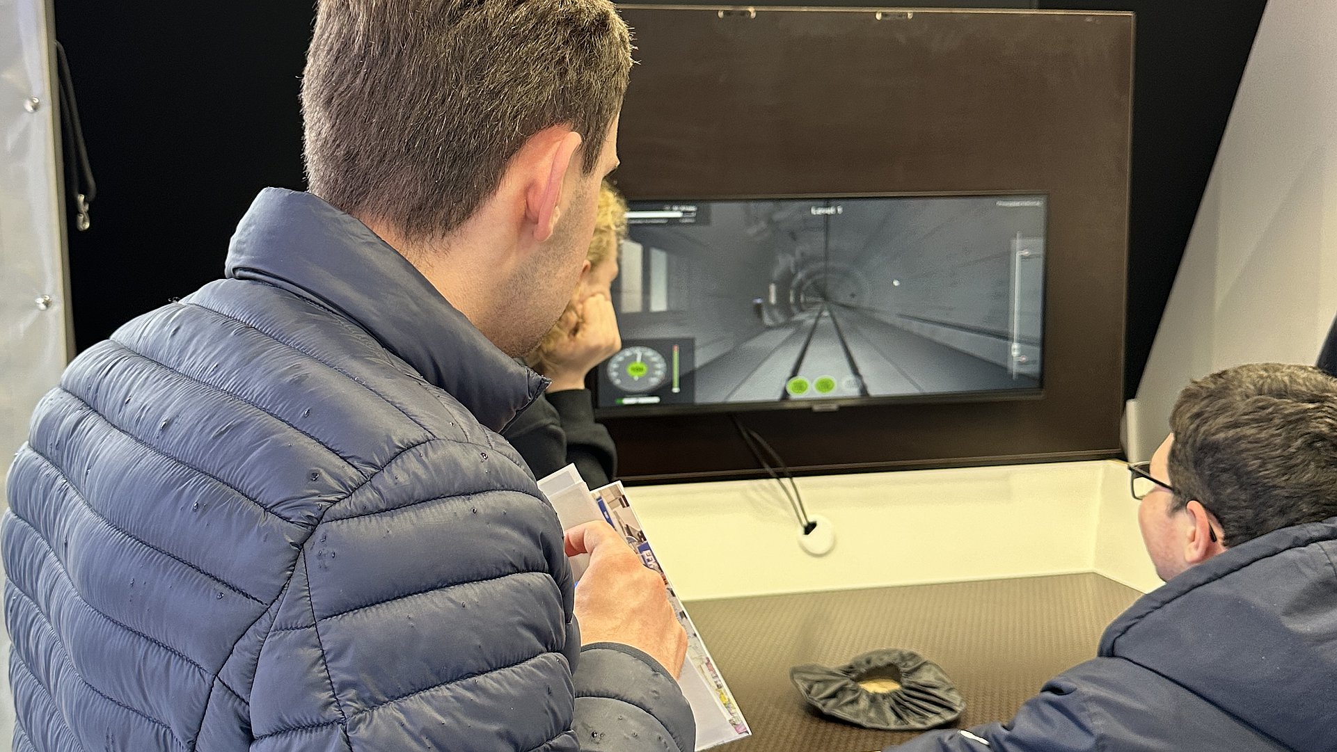 Zwei Teilnehmende testen die Simulationsfahrt mit der U-Bahn an einem Computer