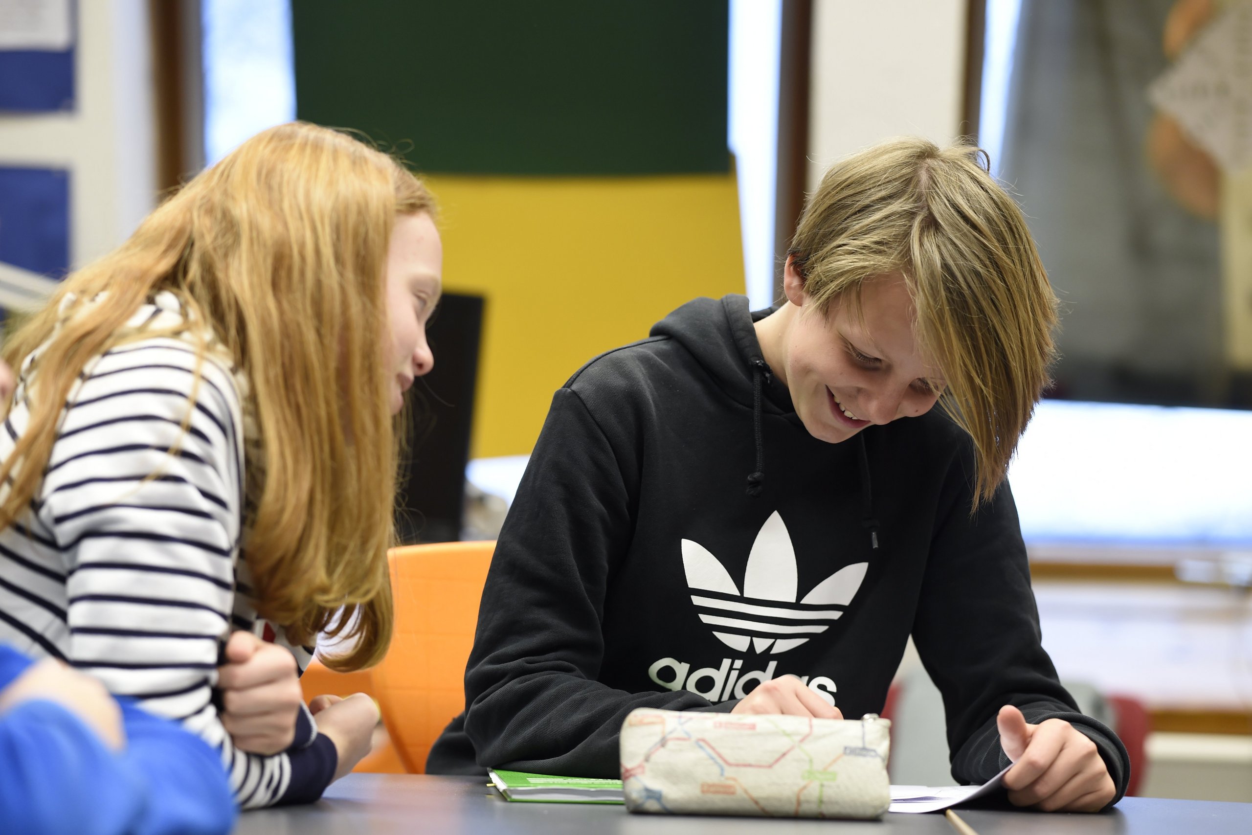 Eine Schülerin hilft einem Schüler beim Lernen