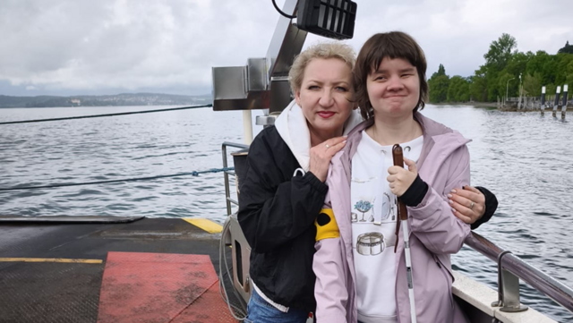 Eine Mitarbeiterin der Nikolausplege steht mit einer Klientin auf dem Deck von einem Schiff. Sie fahren über den Bodensee