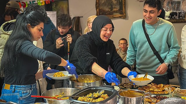 Teilnehmende der Beruflichen Bildung und Mitarbeitende am Buffet bei der Essensausgabe